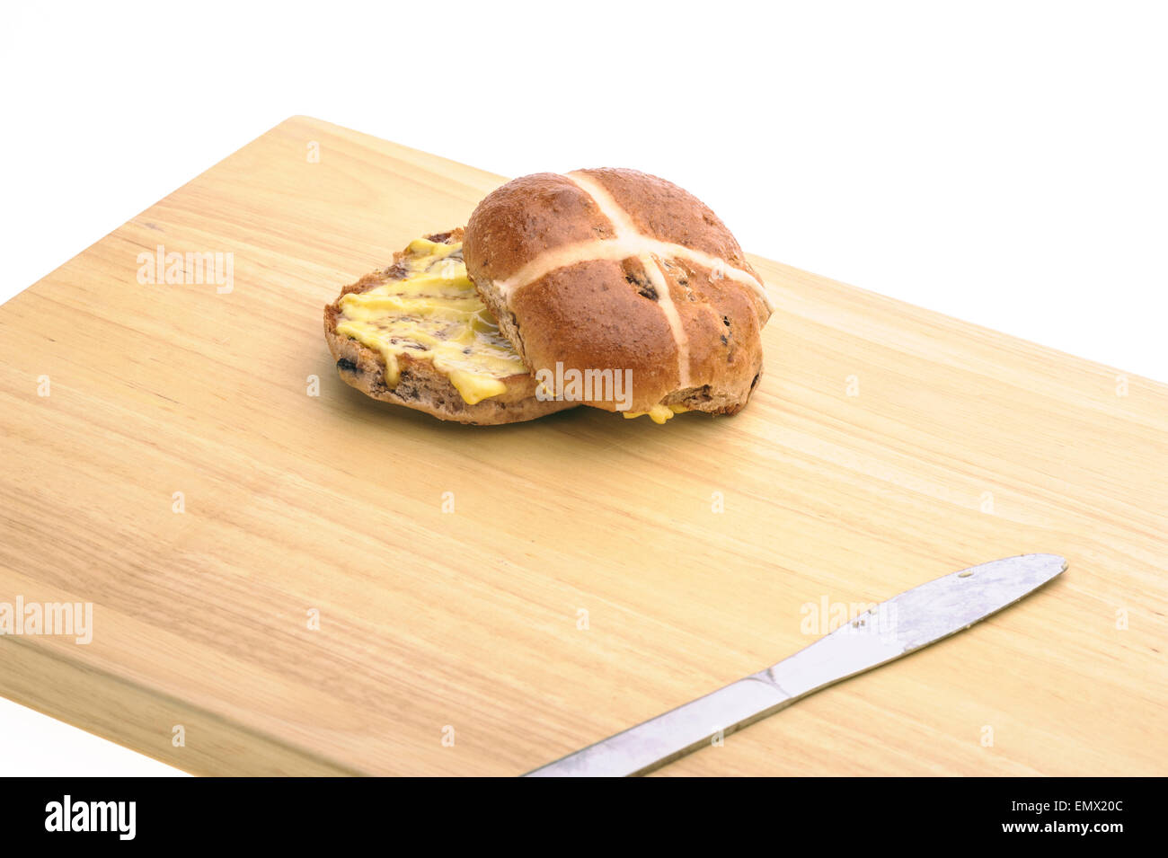 Hot cross bun con coltello su una tavola di legno. Foto Stock