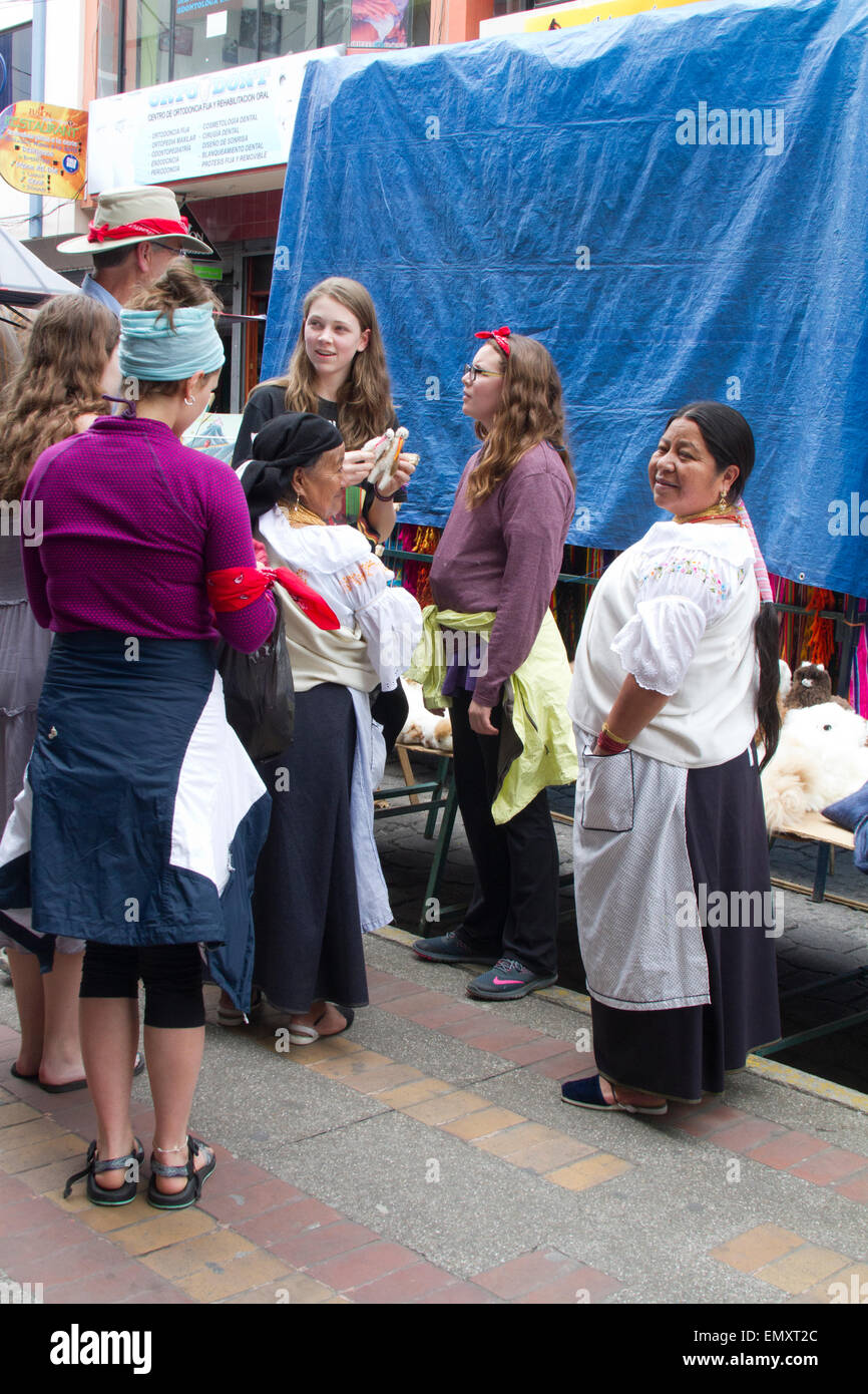 I turisti dello shopping e guardando i prodotti esposti per la vendita al mercato di Otavalo, Ecuador Foto Stock