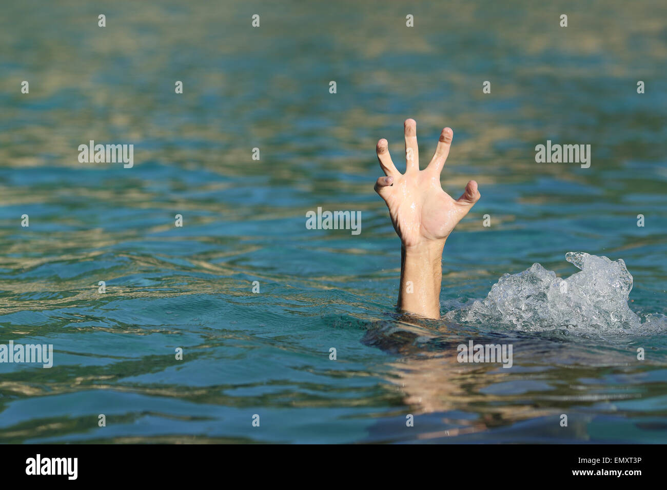 La mano di un uomo che annega nel mare cercando di galleggiante Foto Stock