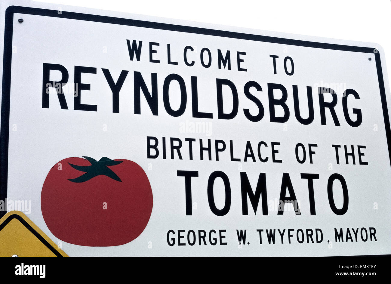 Un segno di benvenuto in Reynoldsburg, Ohio, Stati Uniti d'America, che vanta la città del Midwest è il luogo di nascita del pomodoro. Il suo periodo estivo annuale Sagra del Pomodoro onora un agronomo locale, Alexander Livingston, chi ha creato il mondo a forma di pomodoro Paragon nel 1870 e ha affermato di essere la prima mai il pomodoro allevati per uso commerciale. Ohio è stato ufficiale di frutta è il pomodoro e il suo stato è di bevande di succo di pomodoro. Foto Stock