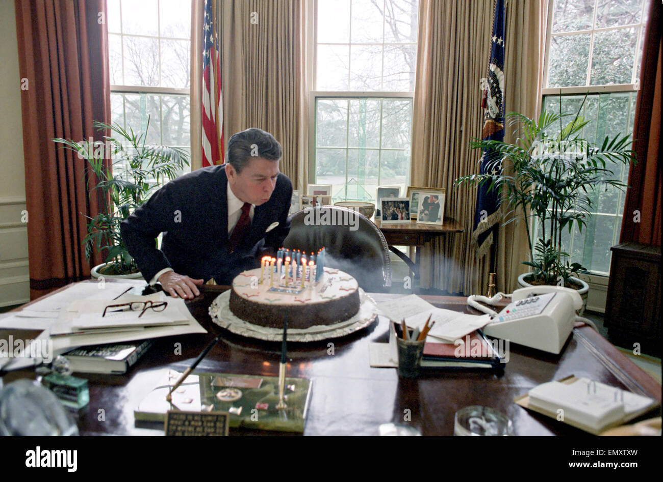 Il presidente statunitense Ronald Reagan si brucia le candeline sulla torta mentre celebra la sua festa di compleanno nell'Ufficio Ovale della Casa Bianca il 5 febbraio 1982 a Washington, DC. Foto Stock