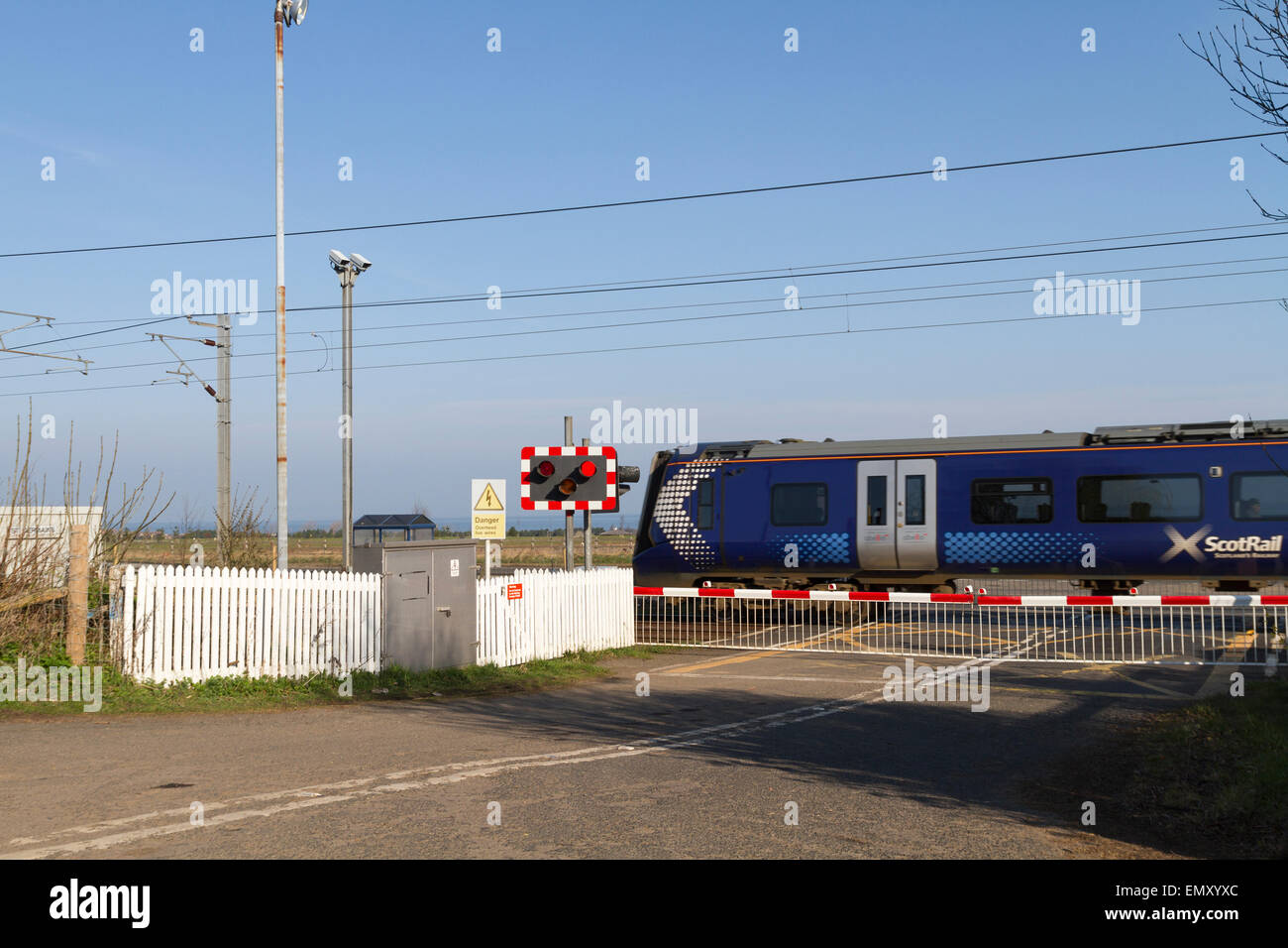 Scotrail treno passa attraverso un passaggio a livello Foto Stock