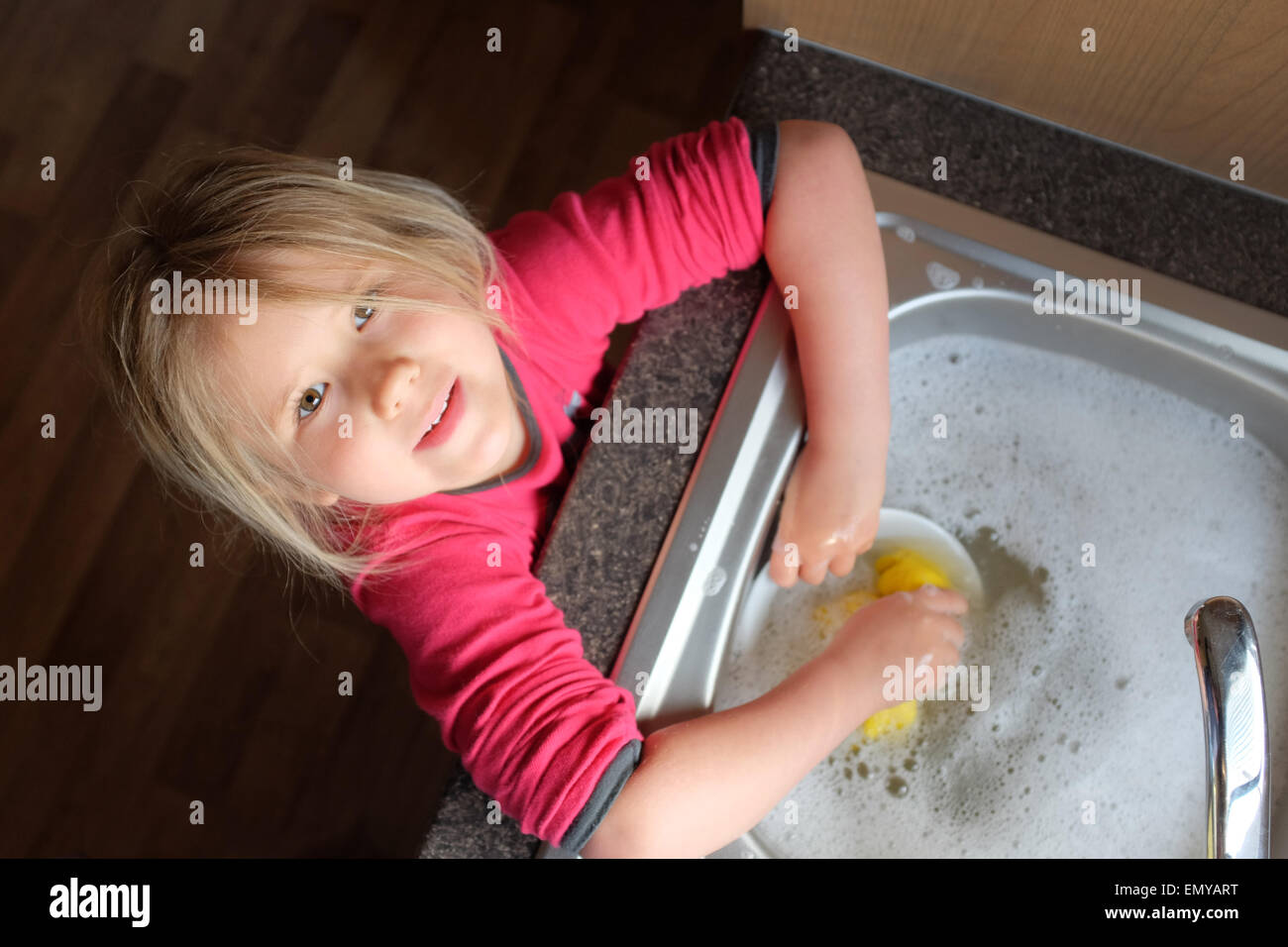 Una giovane ragazza di lavaggio e di asciugatura stoviglie Foto Stock