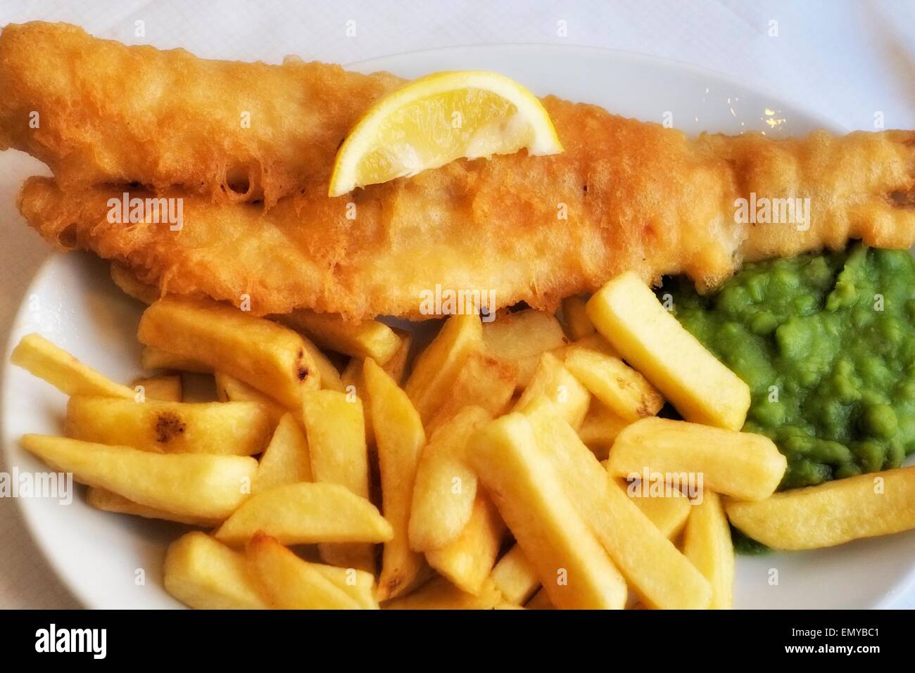 Un piatto di merluzzo, trucioli e fiacco piselli England Regno Unito Foto Stock