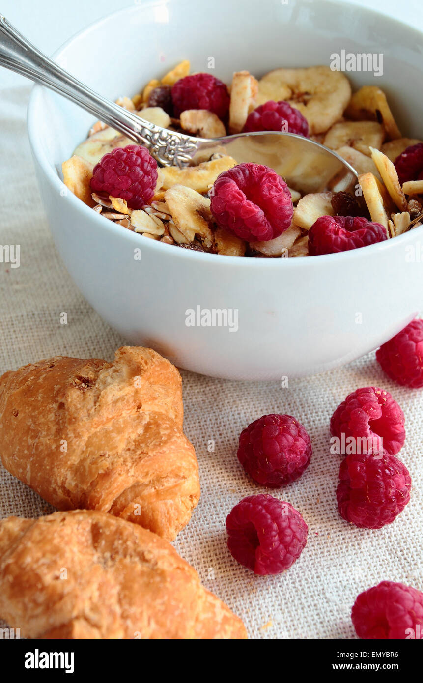 Ciotola con cereali con frutti di bosco freschi e croissant Foto Stock