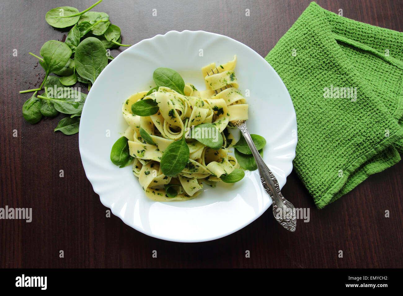 Piastra bianca con le tagliatelle con spinaci freschi Foto Stock