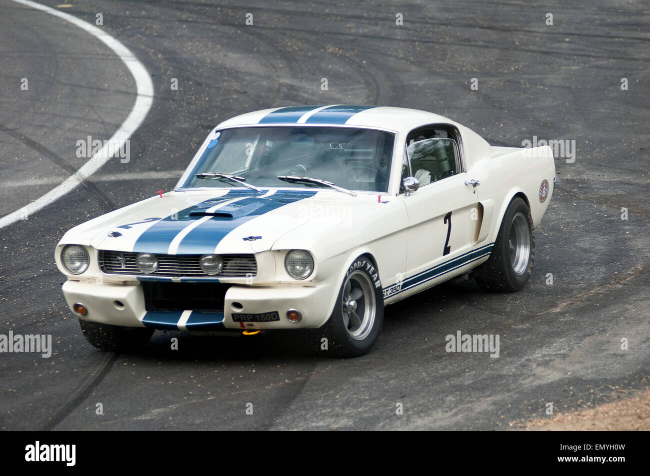 L'immagine mostra un isolato, white classic Mustang parcheggiato sul bordo di una pista. Foto Stock