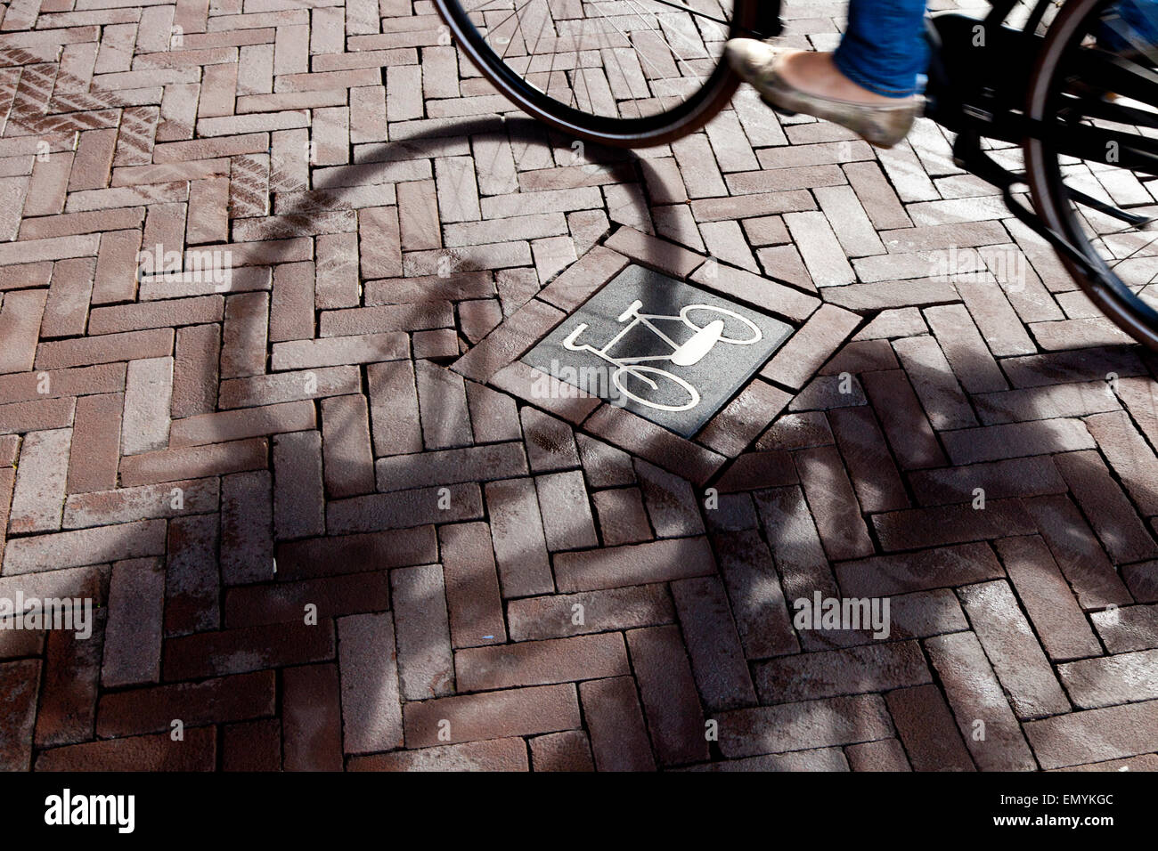 Un segno di bici su strada con l'ombra di un ciclista che va da, Rijksmuseum Amsterdam, Paesi Bassi Foto Stock