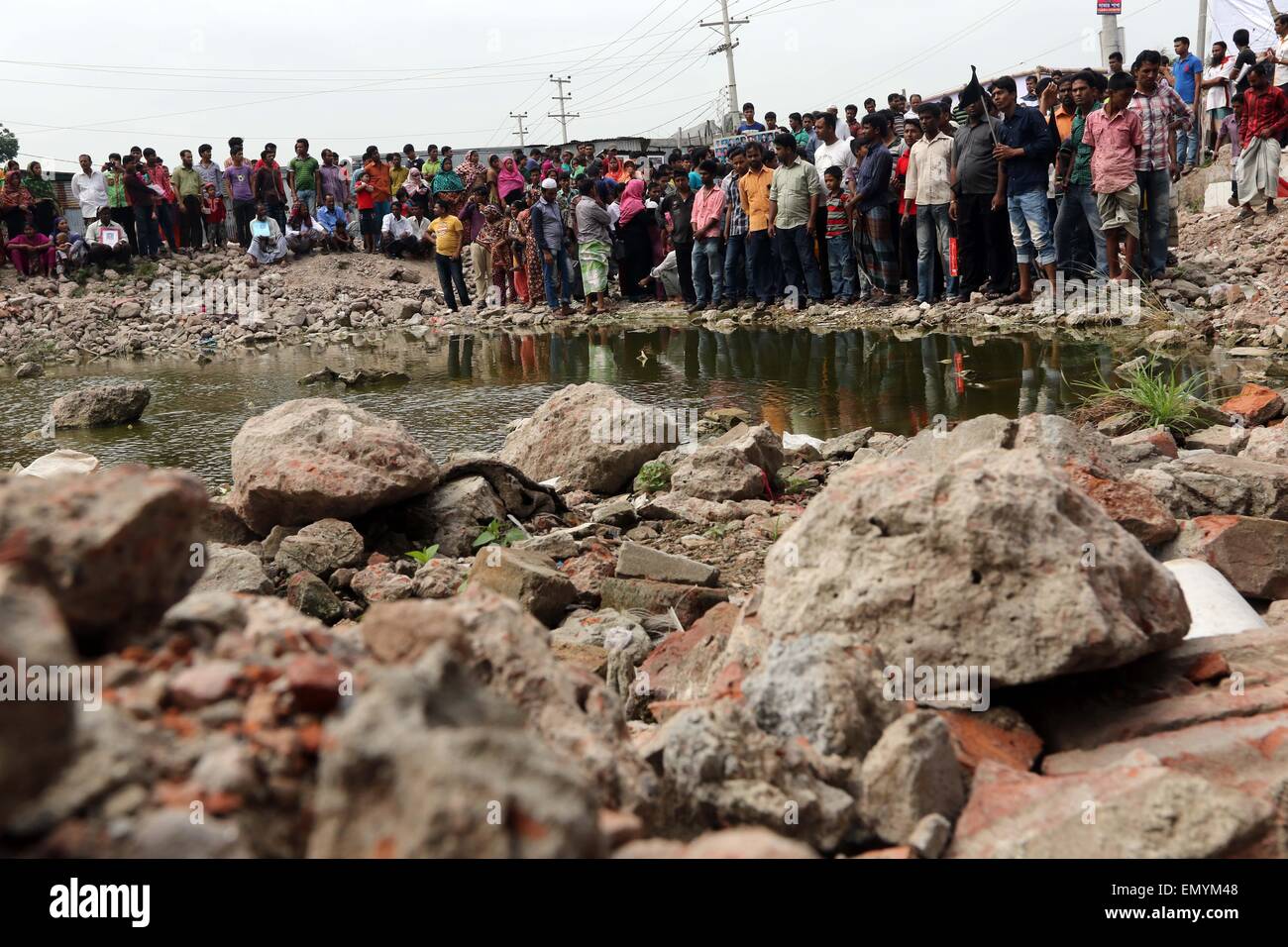 Malaysia i familiari delle vittime di Rana Plaza il crollo dell'edificio, stand presso il sito dell'incidente lungo con attivisti e giornalisti in Savar, vicino a Dacca in Bangladesh, Venerdì, 24 aprile 2015. Il Bangladesh ha subito la peggiore catastrofe industriale quando Rana Plaza, un costruito illegalmente, multistoried edificio situato al di fuori di Dhaka, Bangladesh capitale, crollò nel 2013 uccidendo 1.127 persone ed il ferimento di circa 2.500. Foto di leadfoto Foto Stock