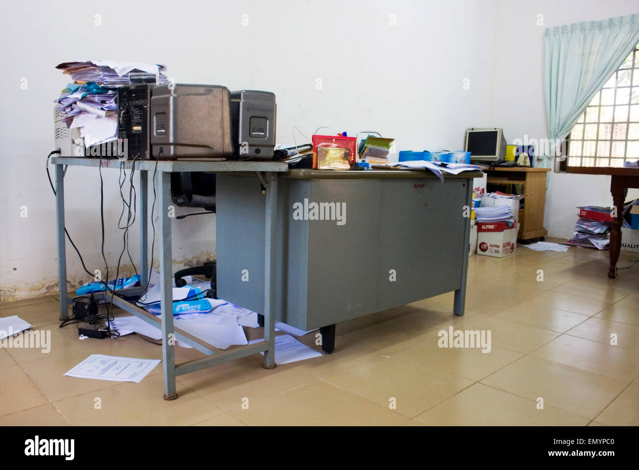 Un Dean's desk è traboccante di pile di carta presso l'Università di Agricoltura in Kampong Cham, Cambogia. Foto Stock