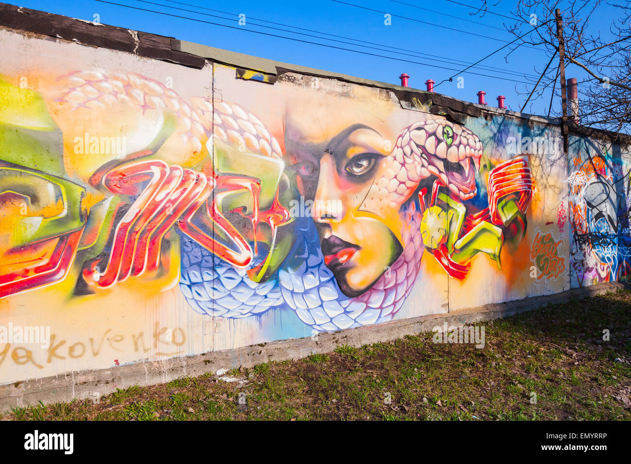 San Pietroburgo, Russia - Aprile 6, 2015: coloratissimo graffito con ragazza ritratto sopra il vecchio cemento grigio pareti garage Foto Stock