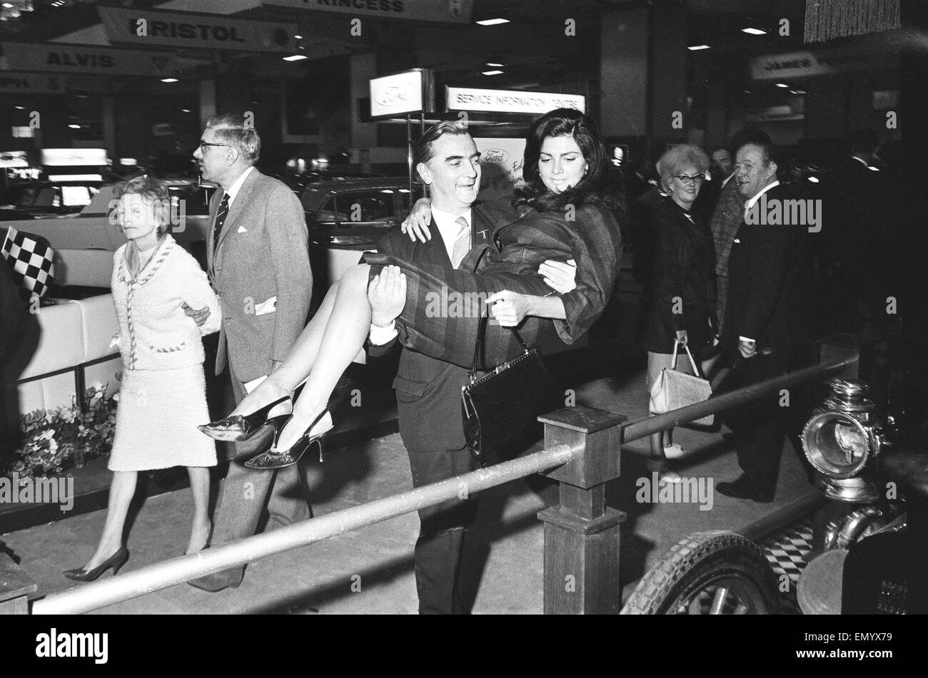 Modello essendo aiutato oltre il barroer ad una gabbia prima che lei pone al British International Motor Show di Londra il 19 ottobre 1965. Foto Stock