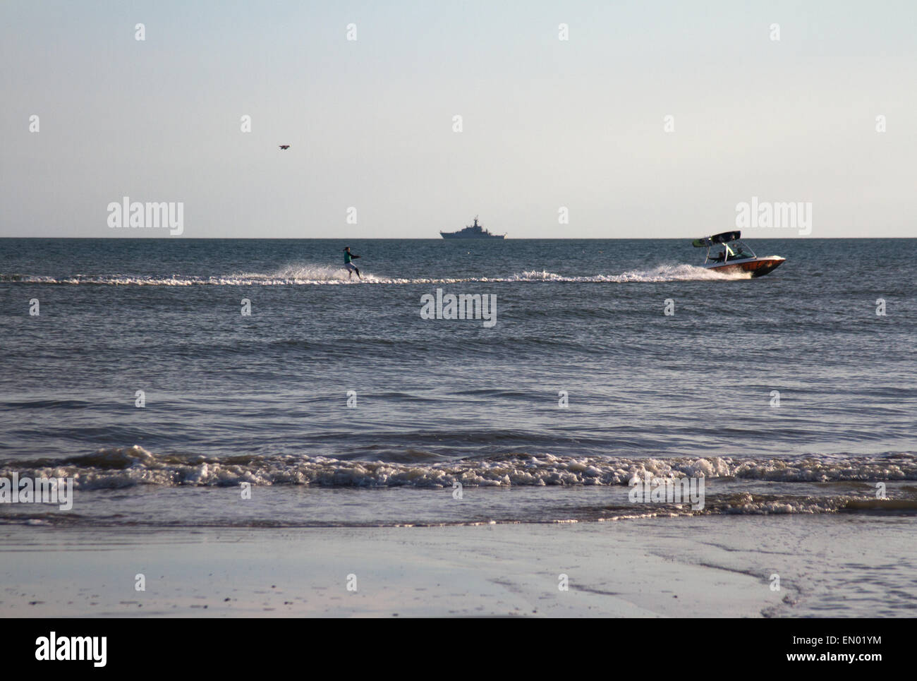 Un acqua-sciatore fuori la spiaggia di Brighton, con una nave da guerra all'orizzonte Foto Stock