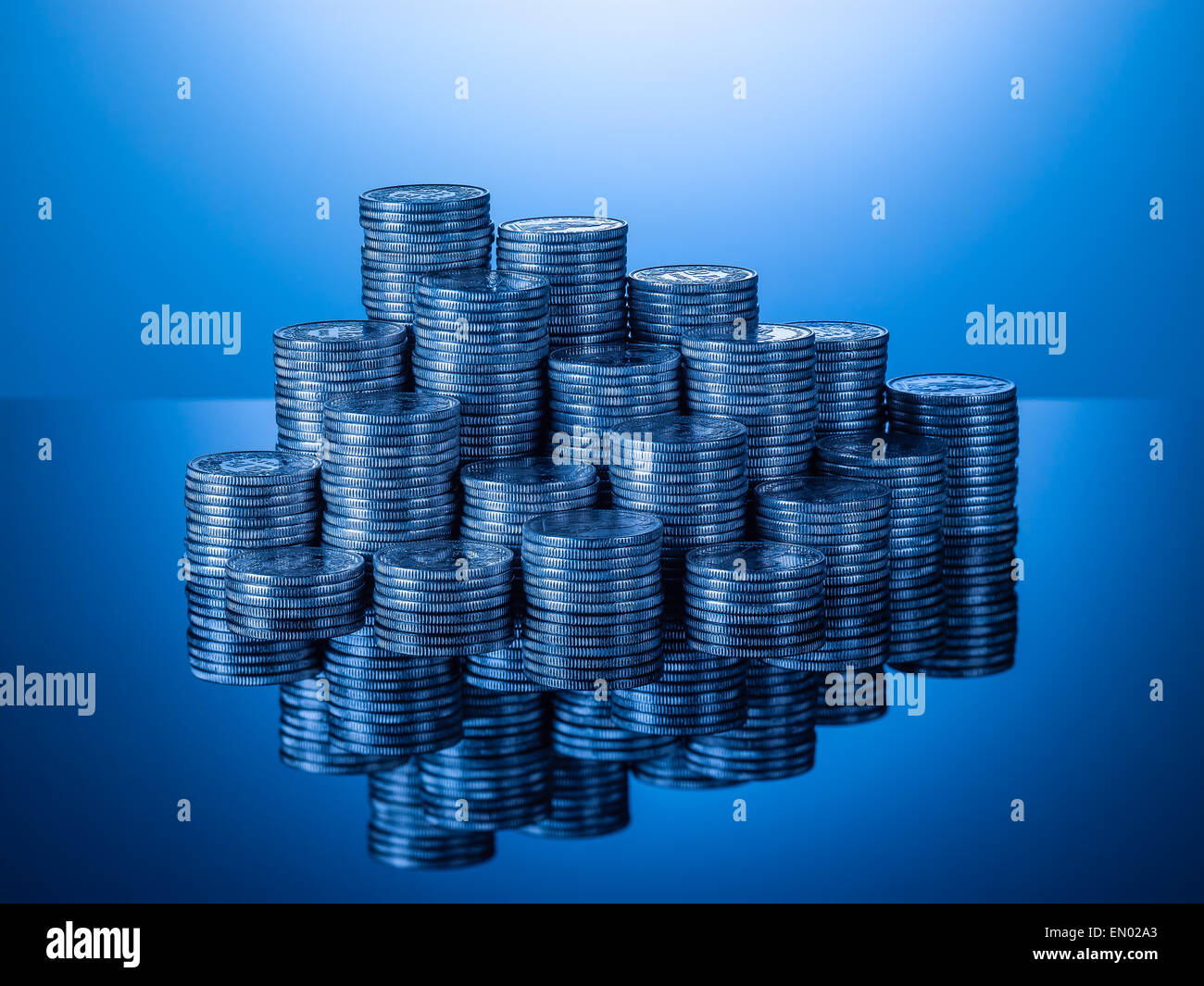 Cataste o pile di monete svizzere, due pezzi di franchi con la riflessione sulla superficie lucida, blu gradiente dello sfondo, formato orizzontale Foto Stock