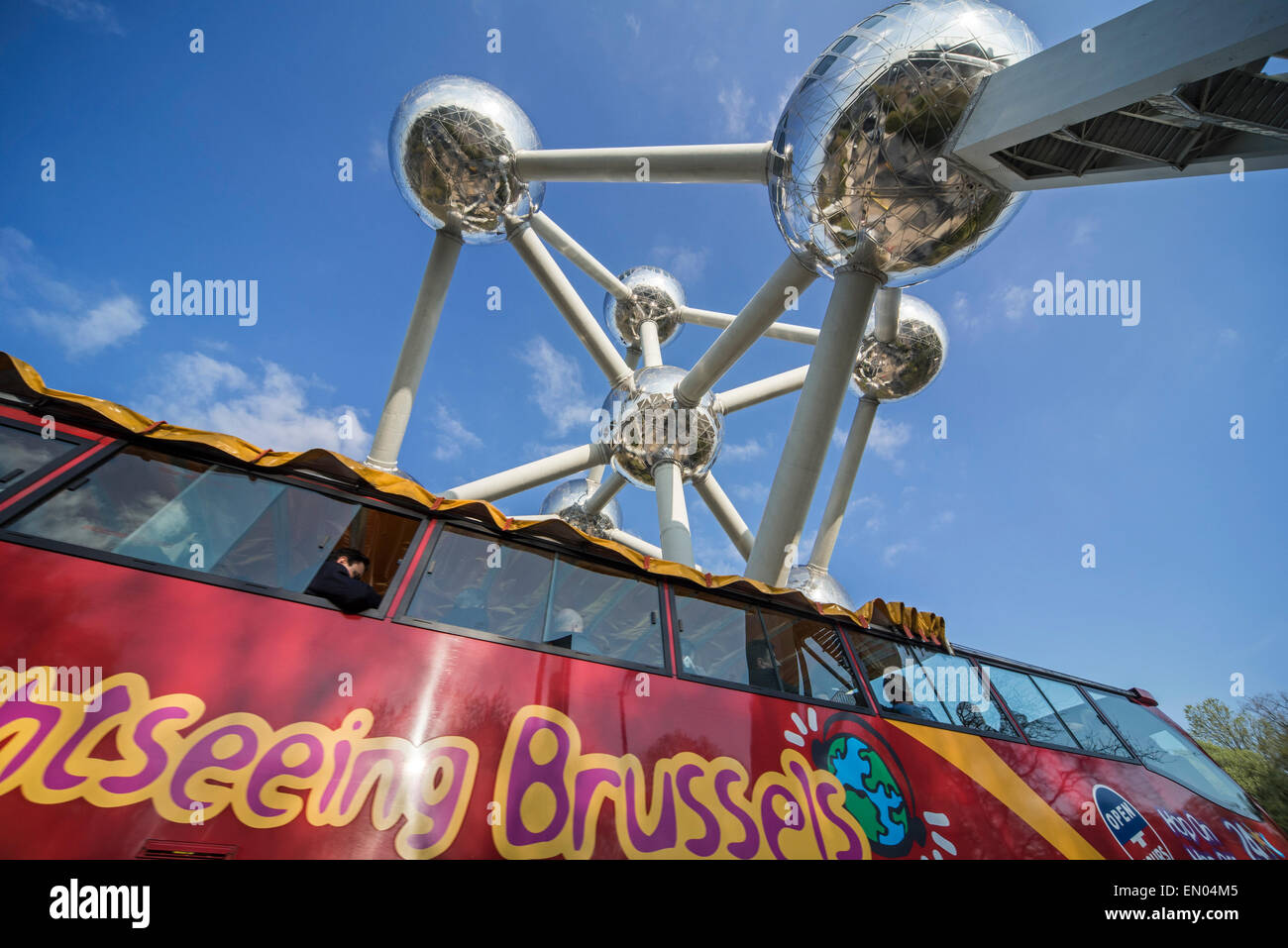 Bus rosso da città turistiche di equitazione a Bruxelles sotto l'Atomium, originariamente costruito per Expo 58 in Belgio Foto Stock