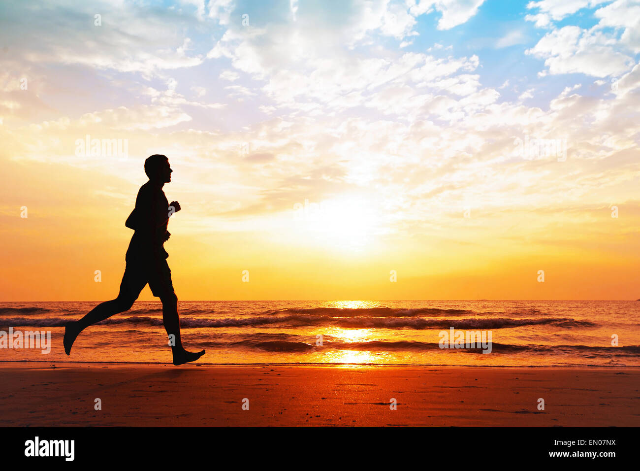 Attiva uno stile di vita sano, silhouette dell'uomo jogging sulla spiaggia Foto Stock