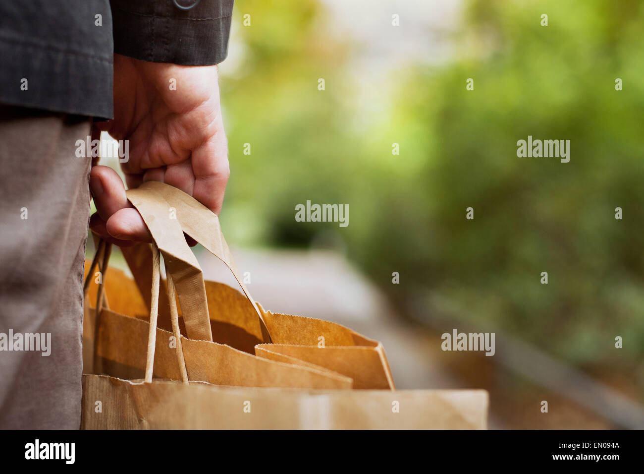 Cestello dei consumatori, close up di carta shopping bags in mano maschio Foto Stock