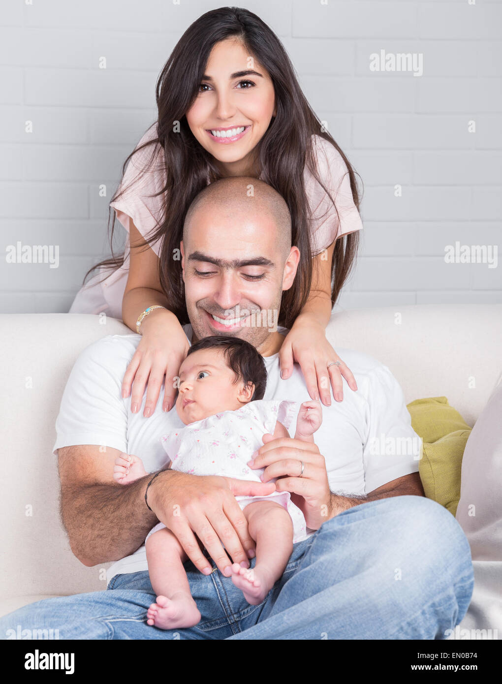 Ritratto di felice famiglia giovane, allegro genitori con cute figlia neonato divertirsi sul lettino a casa, di amore e di felicità Foto Stock