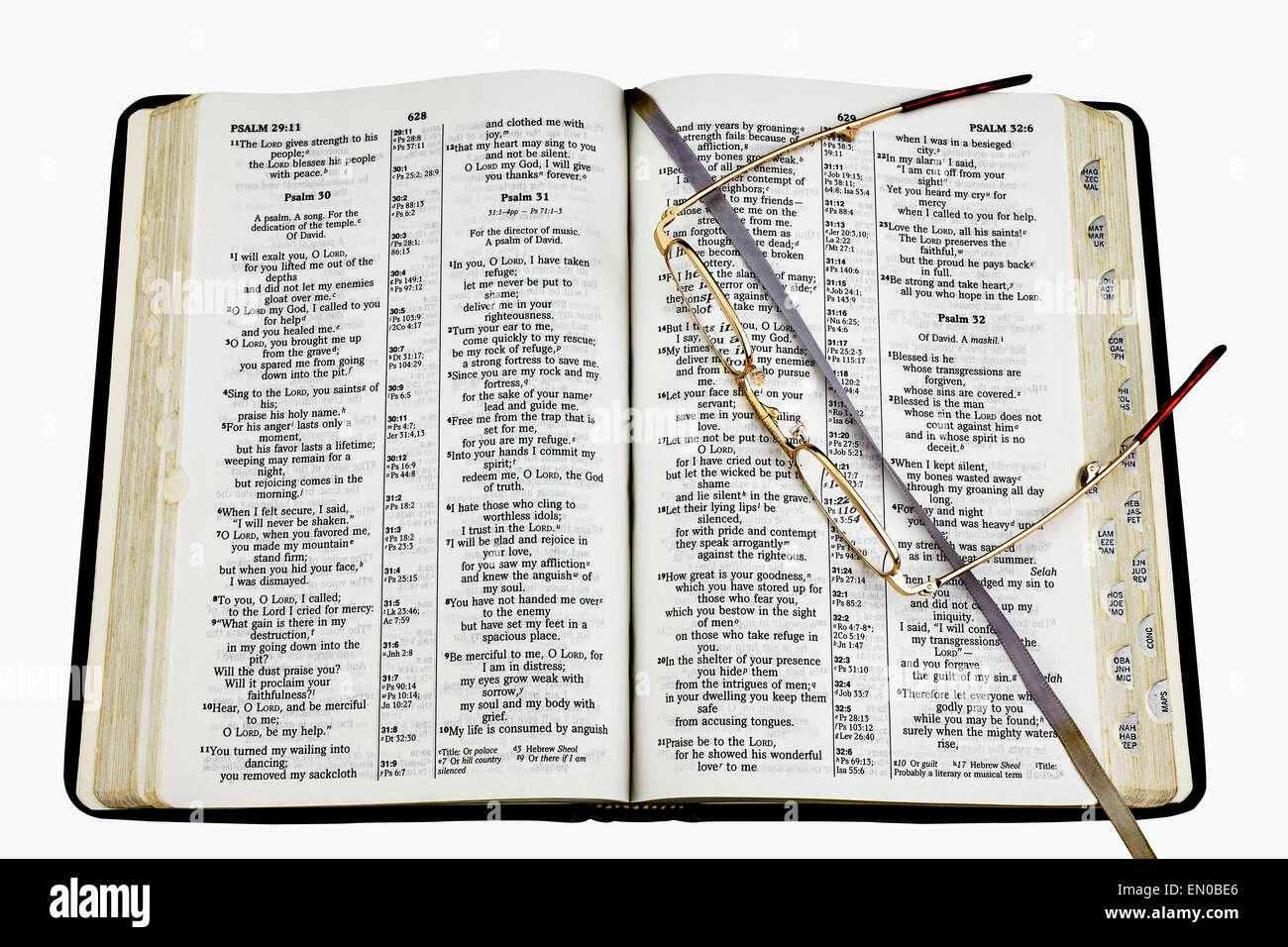 Generic Sacra Bibbia si è rivolta a un passaggio sui Salmi con gli occhiali da lettura isolati su sfondo bianco per l educazione e l apprendimento. Foto Stock