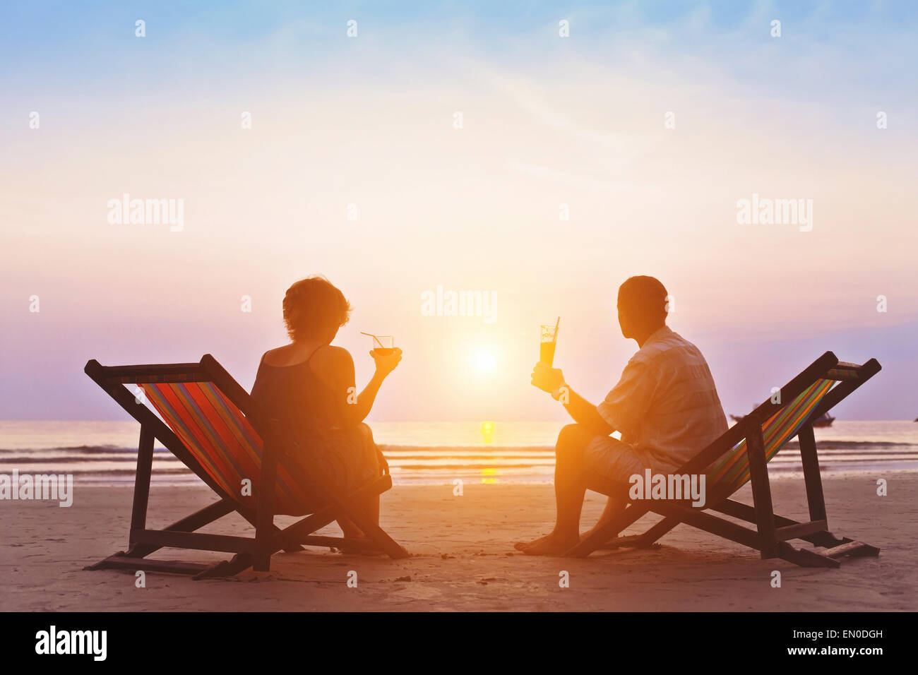 Famiglia godendo romantico tramonto sulla spiaggia Foto Stock