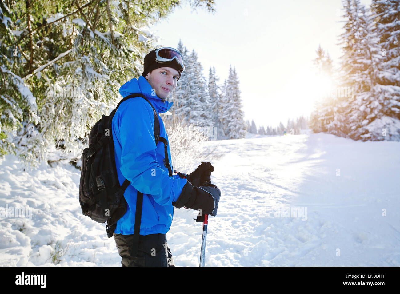 Ritratto di giovane sciatore bello nella foresta di inverno Foto Stock