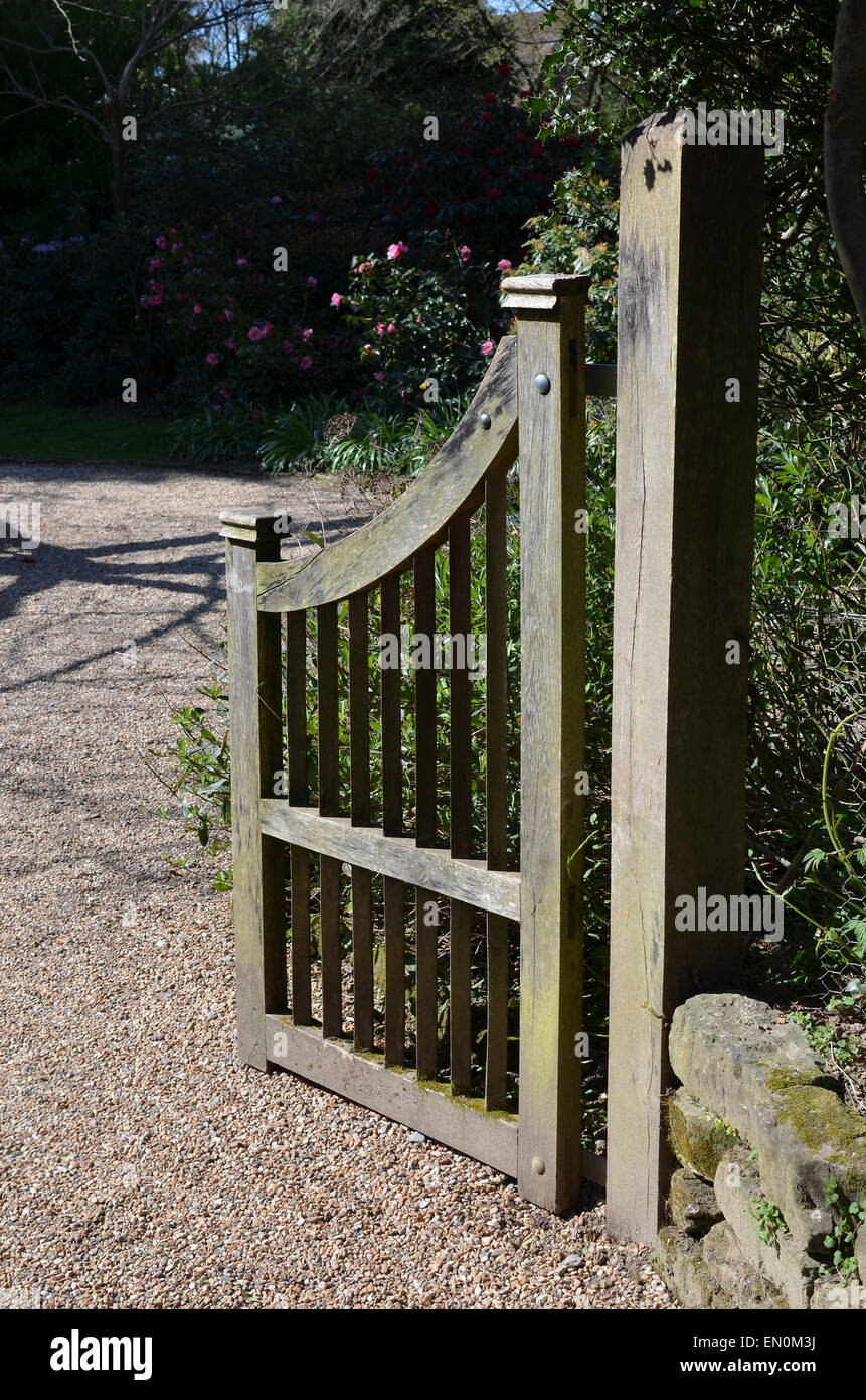 Legno di quercia garden Gate leading per un sentiero di ghiaia. Foto Stock