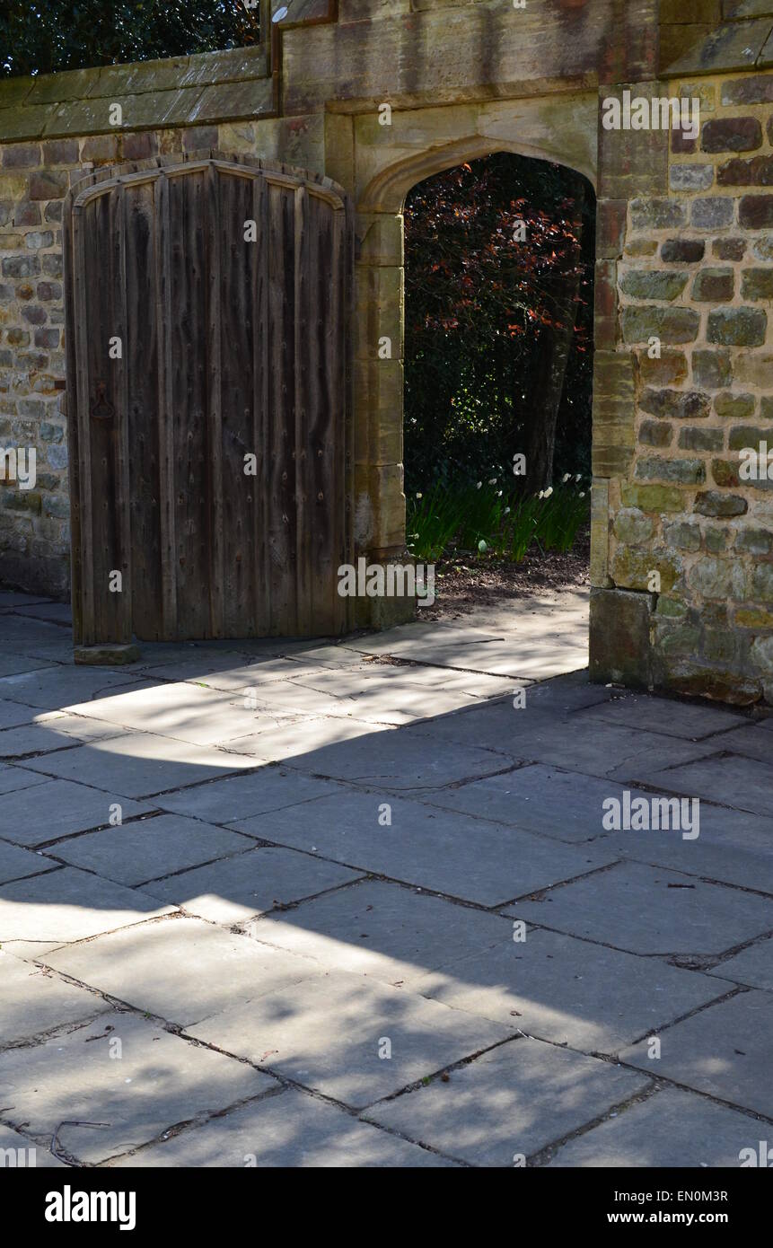 Aprire il legno massello di rovere porta che conduce da un cortile a un giardino segreto. Foto Stock