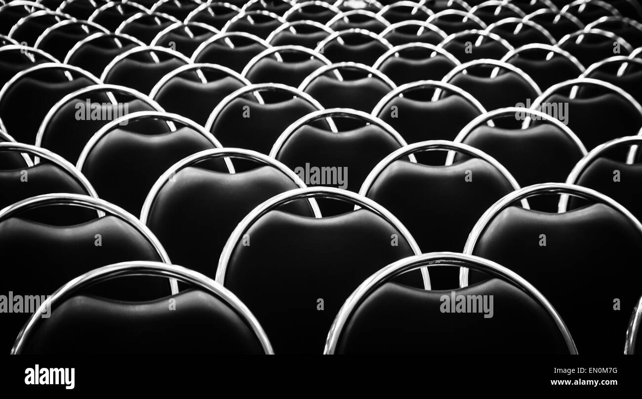 Sfocatura dello sfondo astratto dalla testa di ferro e pelle nera sedia in seminario ,in bianco e nero Foto Stock