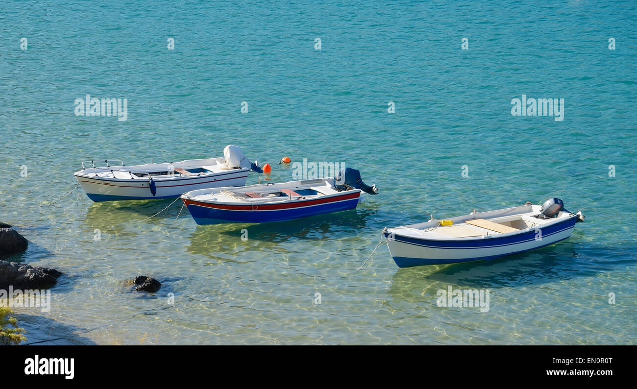 Fila di tre barche ormeggiate in riva al mare Foto Stock