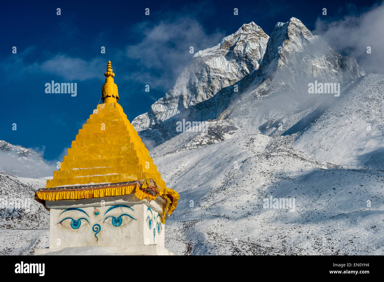 Parco nazionale di Sagarmatha, Nepal - 12 marzo 2015: Ama Dablam picco al tramonto, con la parte superiore di uno stupa in primo piano Foto Stock