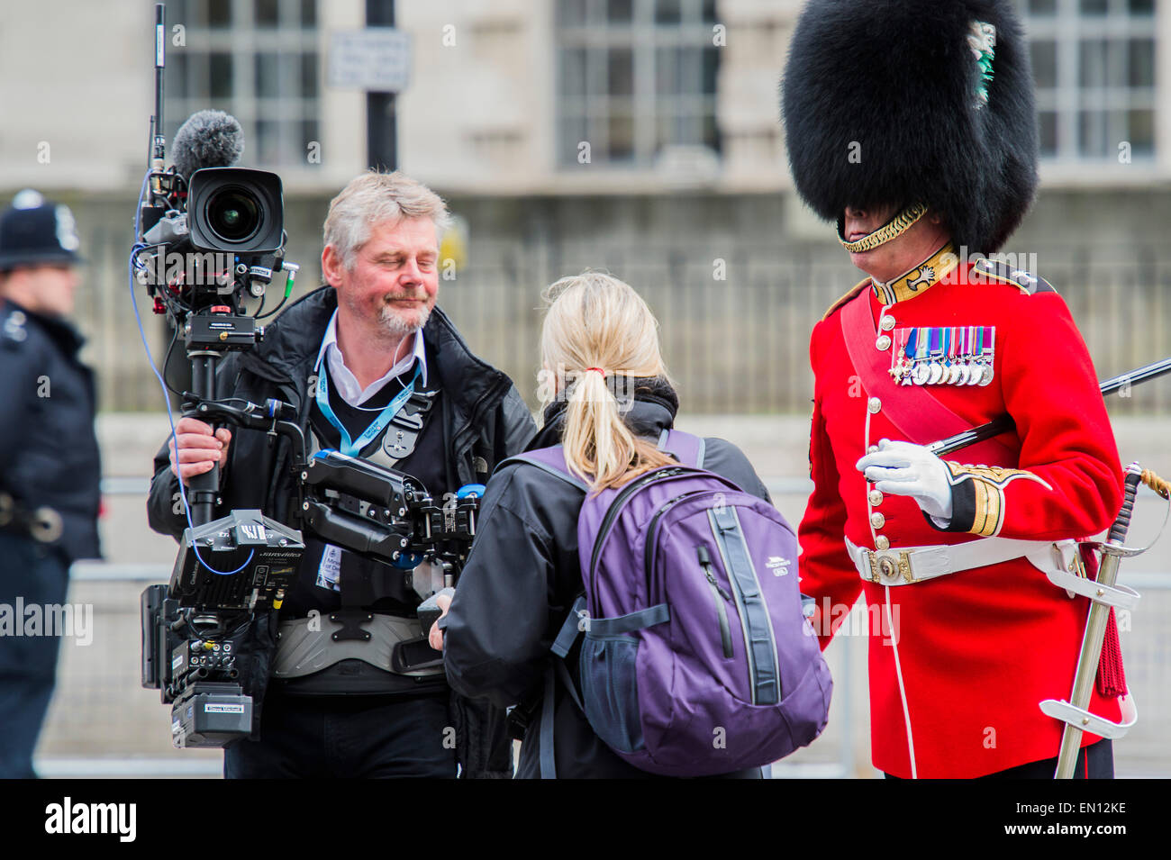 Le protezioni di un sergente maggiore racconta la racconta una troupe televisiva per spostare a. Una commemorazione a Londra in occasione del centenario della campagna di Gallipoli 25 Aprile 2015 presso il Cenotafio su Whitehall, Westminster. I discendenti di coloro che hanno combattuto nella campagna anche marzo passato, guidato dal personale militare, come parte della cerimonia. Si tratta di un'aggiunta alla consueta cerimonia annuale organizzata byvThe elevate commissioni di Australia e Nuova Zelanda. Foto Stock