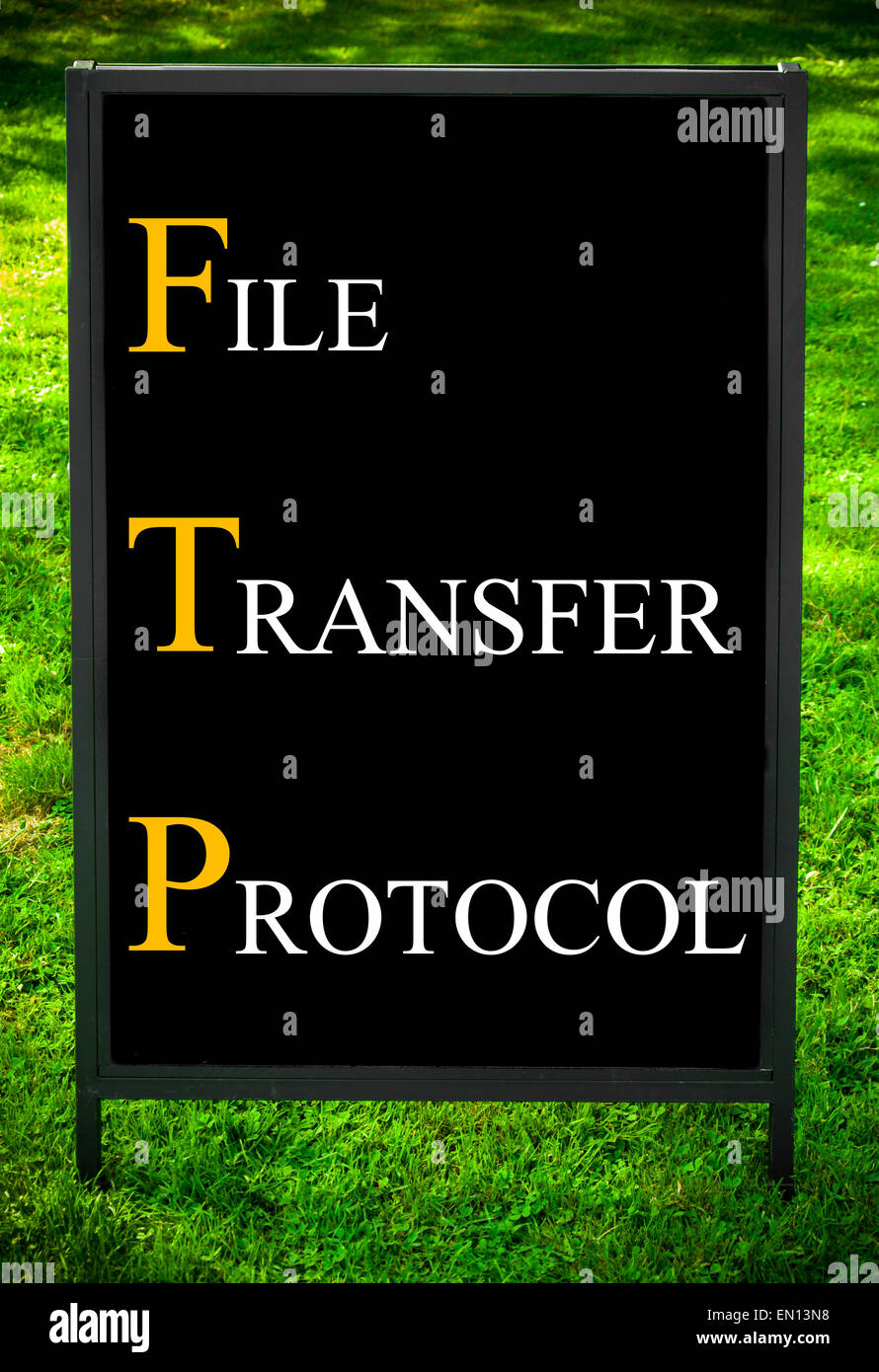 Acronimo di Business FTP come protocollo di trasferimento di file. Messaggio sul marciapiede di blackboard segno contro erba verde dello sfondo. Concetto di immagine Foto Stock