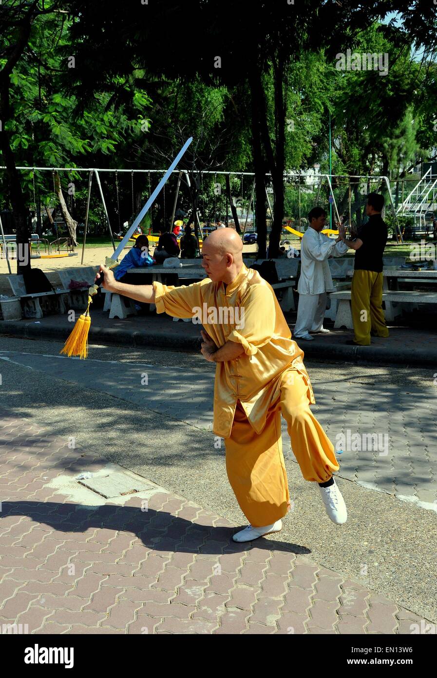 Bangkok, Thailandia: tailandese uomo brandisce una spada di eseguire il Tai Chi esercita nel Parco Lumphinee Foto Stock