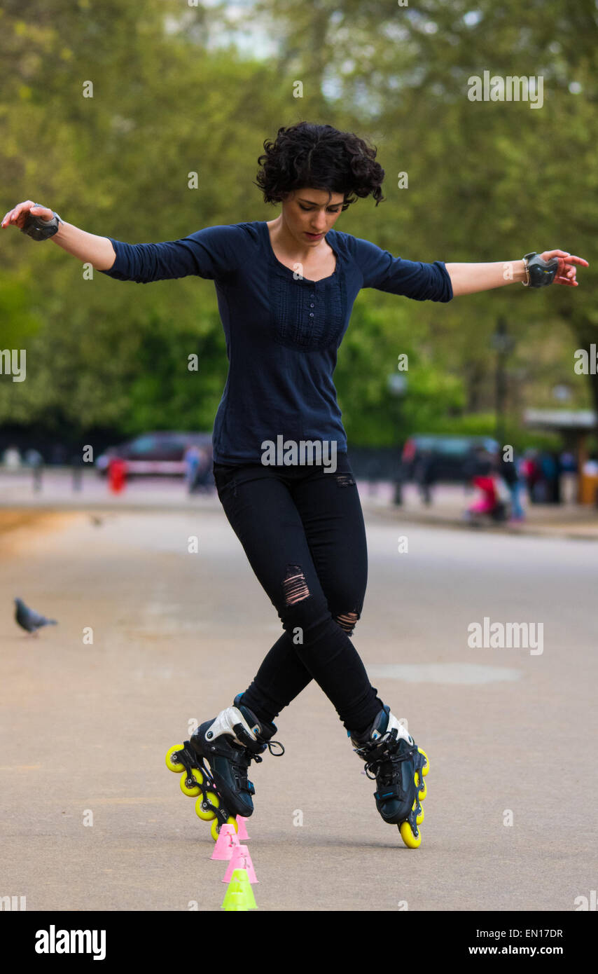 Londra, 25 aprile 2015. Nonostante la minaccia di previsione di docce, sole primaverile e il calore saluta i londinesi di cui godono i parchi reali nella capitale. Nella foto: una donna la sua prassi inline skating competenze in Hyde Park. Credito: Paolo Davey/Alamy Live News Foto Stock