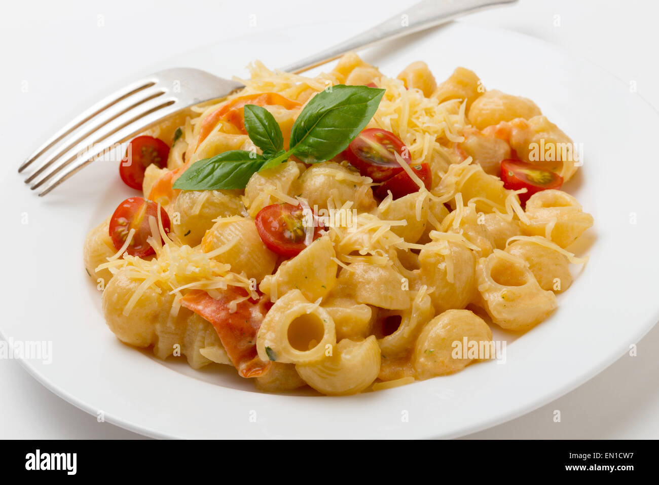 Gomiti rigata gomito pasta condita con i pomodori cotti in crema con pesto verde, pomodorini e parmigiano grattugiato. Foto Stock