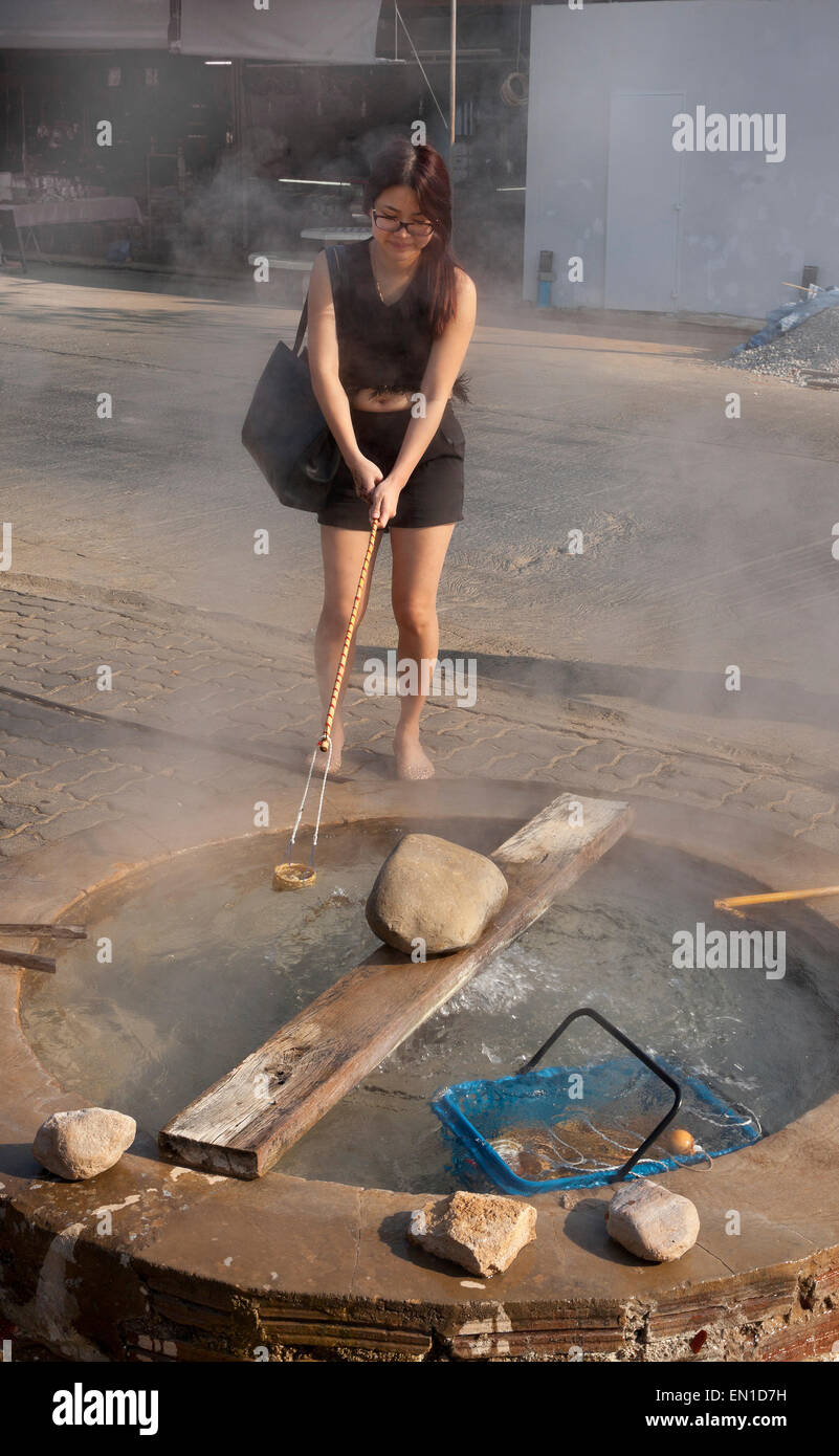 Sorgenti di acqua calda a Wieng Pa Pao, Chiang Rai, nel nord della Thailandia. Giovane donna bollire le uova in acqua calda Foto Stock