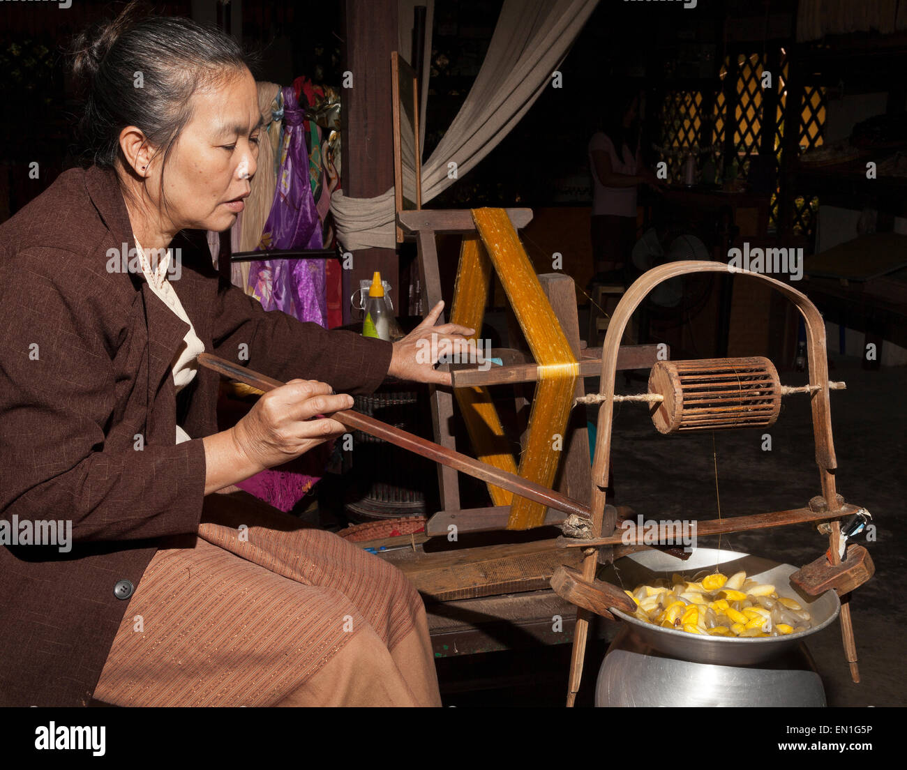 Lavoratore di seta, filetto di filatura da bozzoli, Chiang Mai, Thailandia Foto Stock