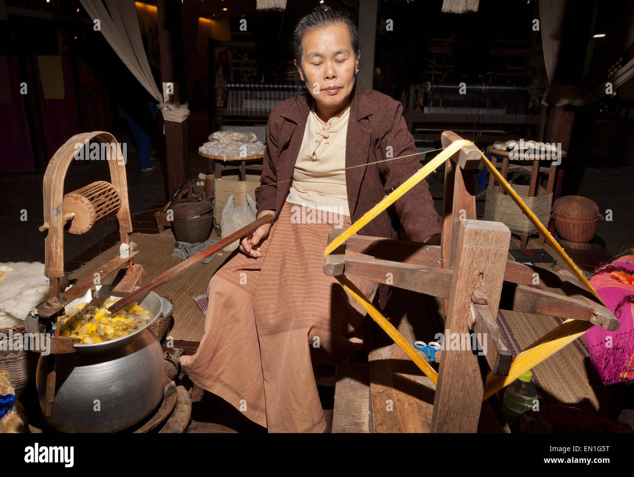Lavoratore di seta, filetto di filatura da bozzoli, Chiang Mai, Thailandia Foto Stock