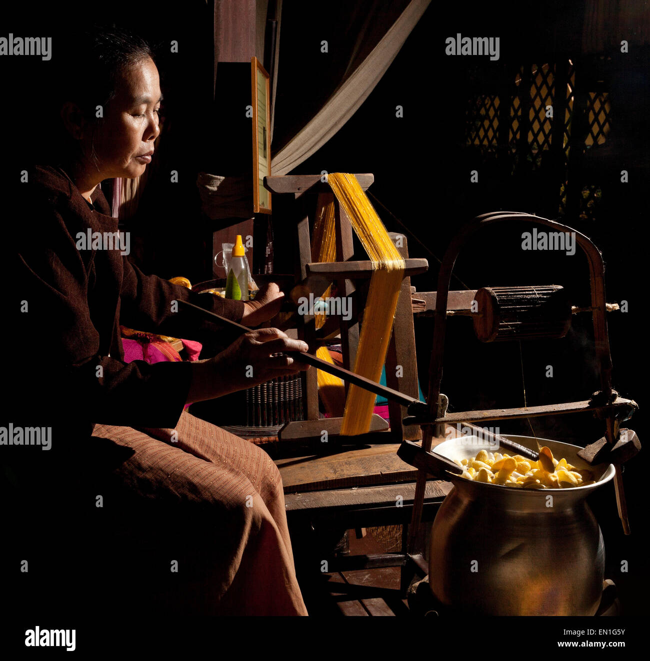 Lavoratore di seta, filetto di filatura da bozzoli, Chiang Mai, Thailandia Foto Stock