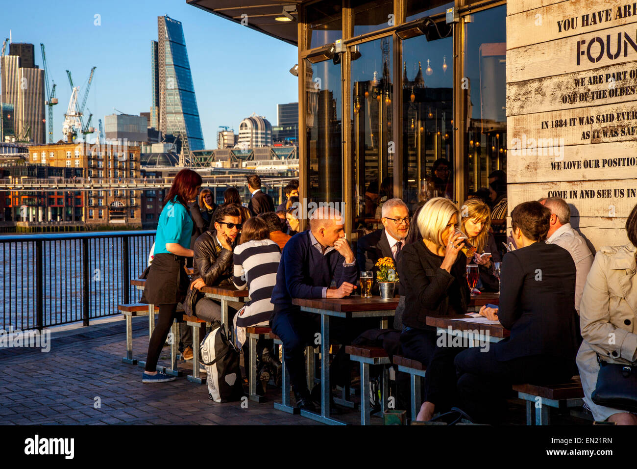 Lavoratori di uffici e rilassante bevendo al fondatore di braccia Riverside Pub di Londra, Inghilterra Foto Stock