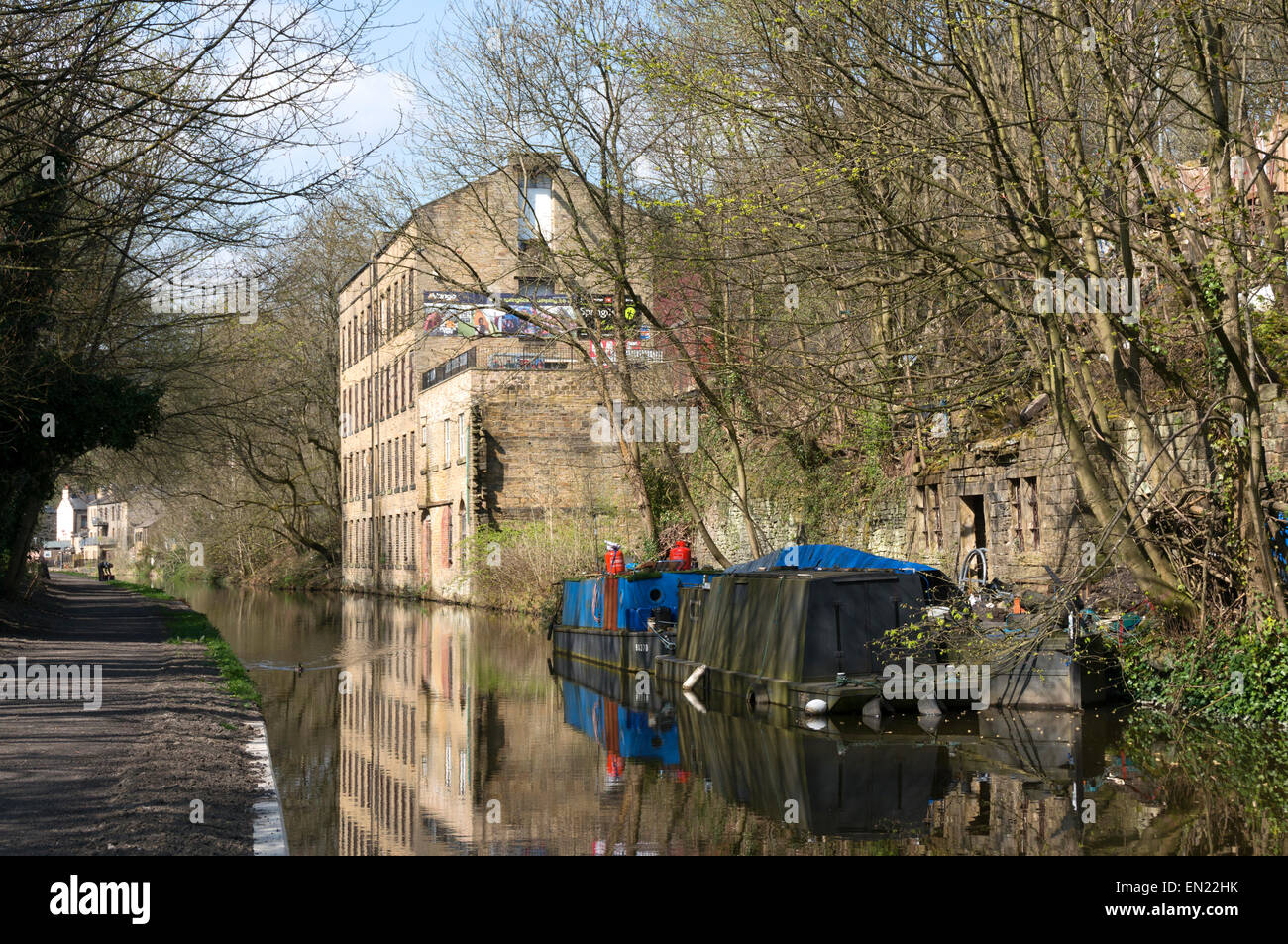 Vecchio mulino e barche si riflette in Rochdale Canal, Luddenden piede, West Yorkshire Foto Stock