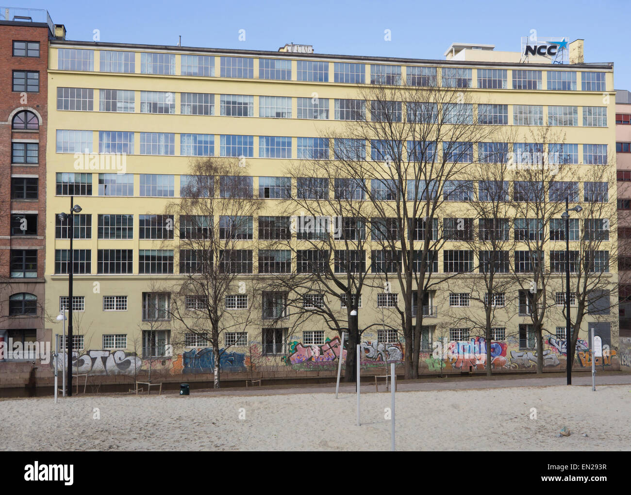 Facciata del vecchio edificio in calcestruzzo lungo Akerselva in Oslo Norvegia, ex fabbrica con un sacco di finestre per la luce e graffiti Foto Stock