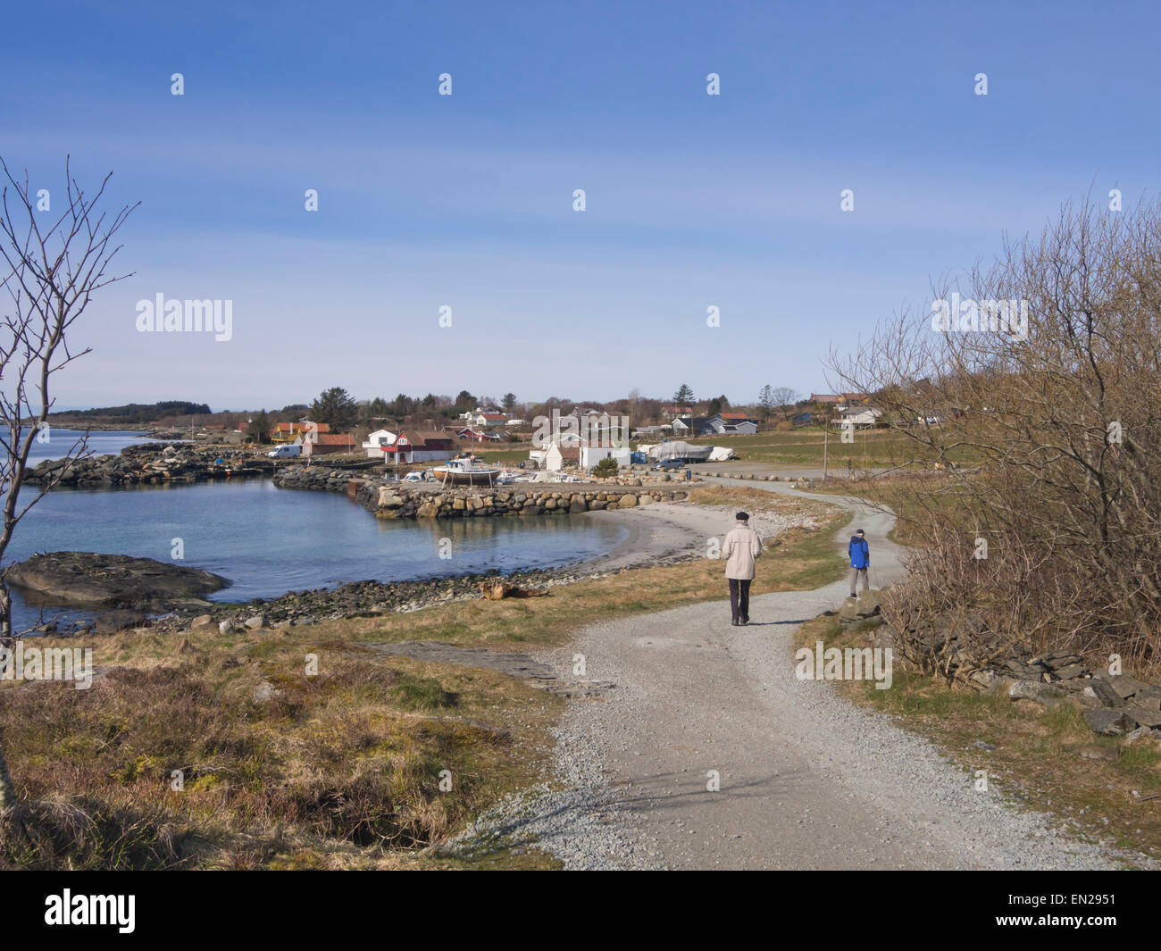 Due dei cittadini anziani a piedi su un sentiero lungo la costa del Mare del Nord nella periferia di Stavanger, Norvegia in una giornata di sole Foto Stock