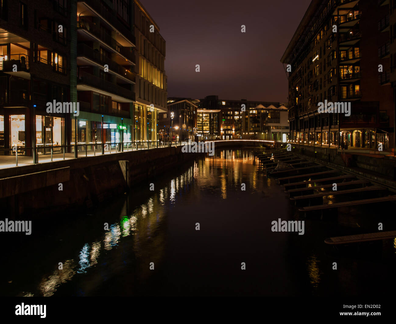 Notte foto di un gruppo di edifici con le sue luci riflesse nell'acqua. Foto Stock