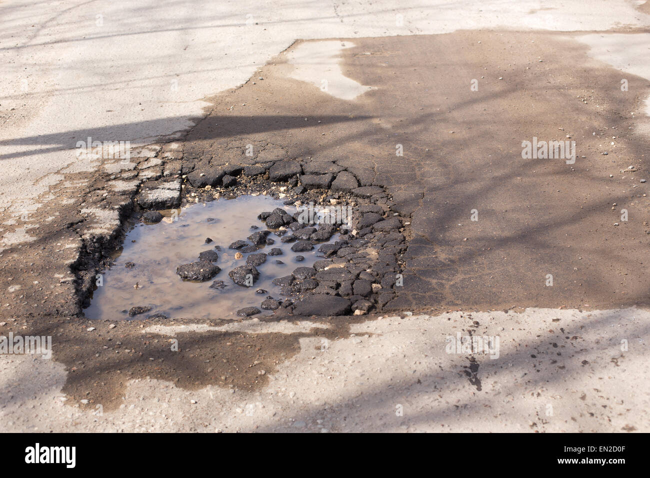 Rotture di asfalto e buca sulla strada pericolosa per gli automobilisti Foto Stock