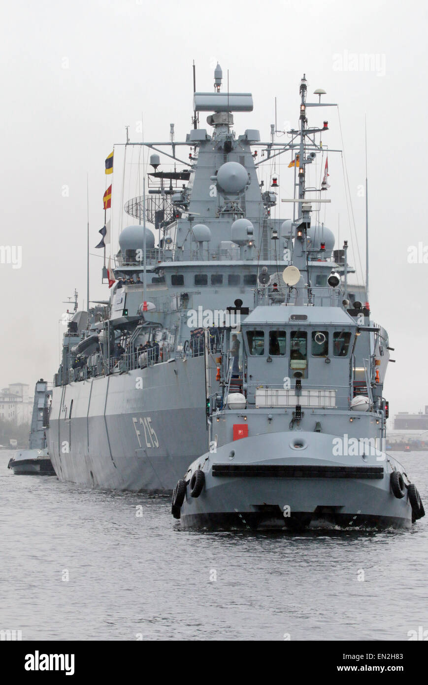 Wilhelmshaven, Germania. 26 apr, 2015. Un rimorchiatore accompagnatrici la fregata F215 'Brandeburgo' della Marina tedesca al suo arrivo presso la sua casa porto di Wilhelmshaven, Germania settentrionale, domenica 26 aprile, 2015. Le navi di ritorno da un viaggio di tre mesi durante i quali ha preso parte alla Obangame Express 2015 operazione presso il golfo di Guinea. Credito: Focke Strangmann/Alamy Live News Foto Stock