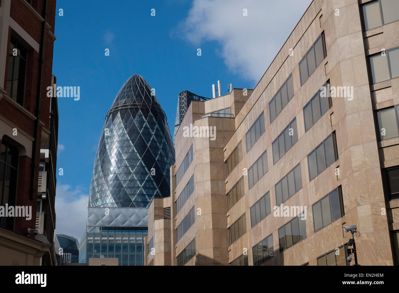 " Il Gherkin' skyscraper (30 St Mary Axe) che si eleva al di sopra degli edifici circostanti a Londra, Inghilterra. Foto Stock