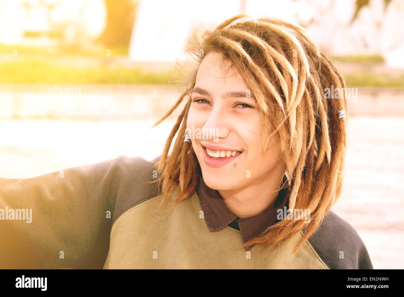 Ritratto di uno stile di vita di un giovane uomo con capelli rasta toni caldi filtro applicato Foto Stock