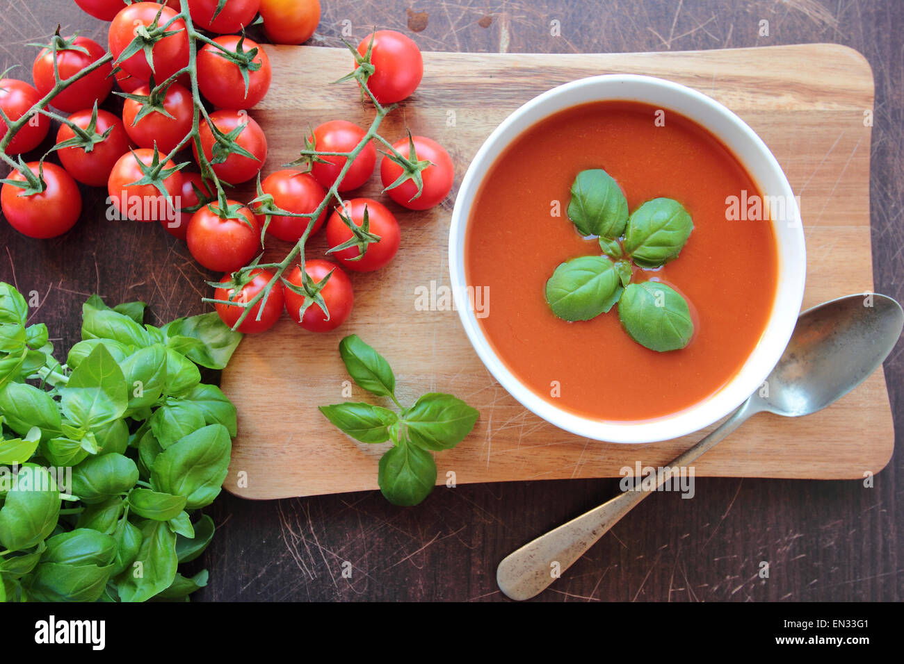 Ciotola con zuppa di pomodoro con foglie di basilico Foto Stock