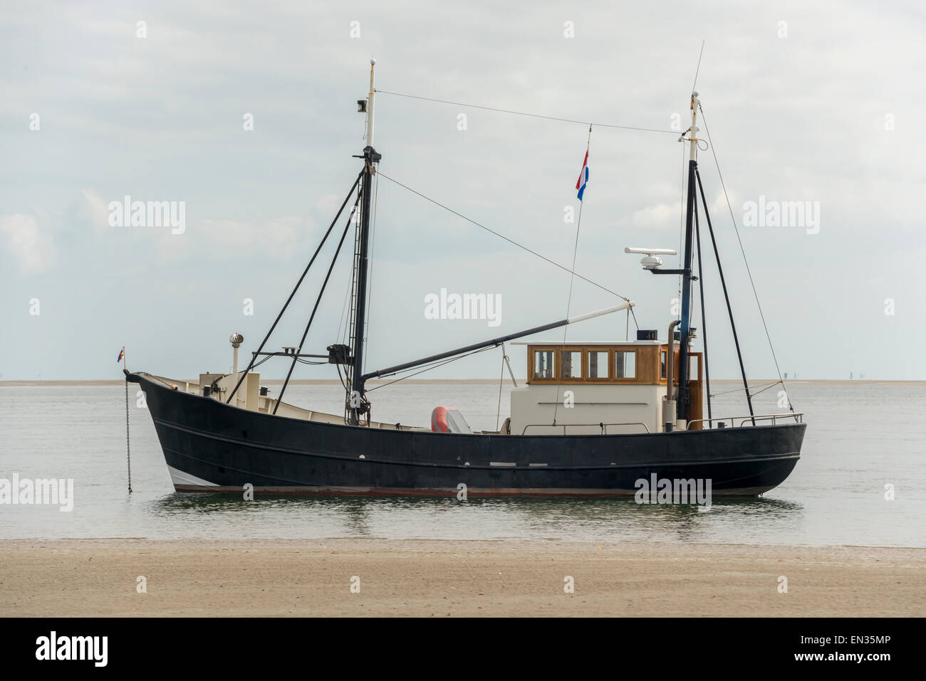 Barca da pesca vicino alla spiaggia olandese sul mare di Wadden Foto Stock